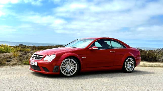 A red 2008 Mercedes Benz CLK63 Black Series is parked near the ocean