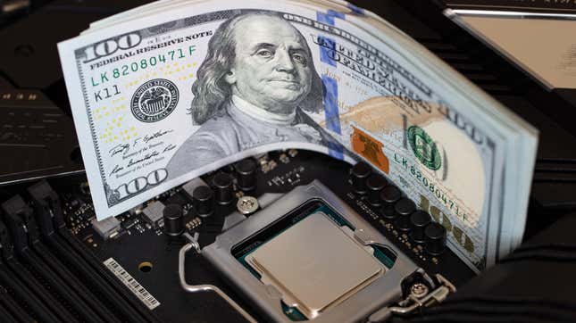 A stack of 100 dollar bills lying next to the uncovered CPU on a computer motherboard.