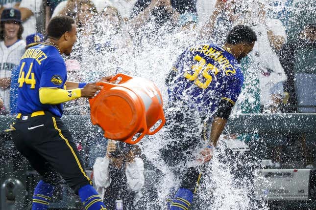 Jul 21, 2023; Seattle, Washington, USA; Seattle Mariners designated hitter Teoscar Hernandez (35) receives a water-bucket dunking from center fielder Julio Rodriguez (44) after hitting a walk-off RBI-single against the Toronto Blue Jays during the ninth inning at T-Mobile Park.