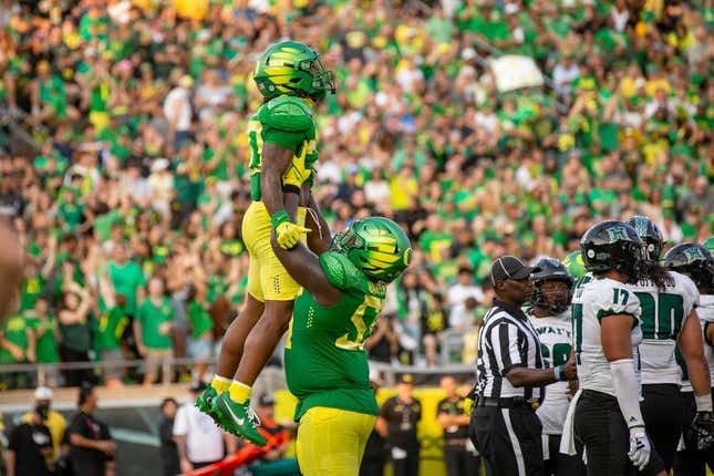 Oregon running back Jordan James is lifted into the air by teammate Marcus Harper II to celebrate a touchdown as the Oregon Ducks host Hawaii Saturday, Sept. 16, 2023, at Hayward Field in Eugene, Ore.