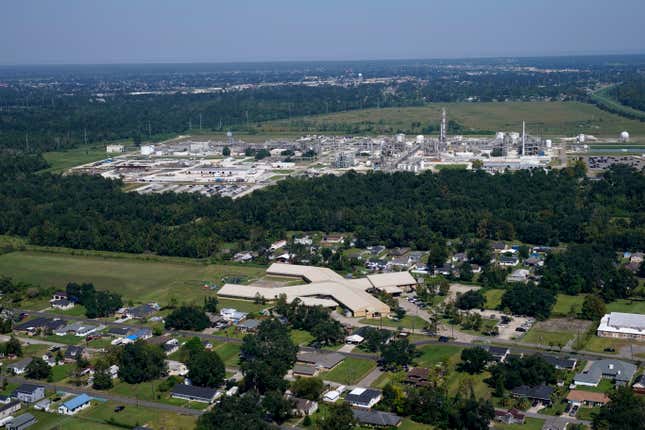 The Fifth Ward Elementary School and residential neighborhoods sit near the Denka Performance Elastomer Plant, back, in Reserve, La., Sept. 23, 2022. Federal officials are suing Louisiana chemical maker Denka Tuesday, Feb. 28, 2023, alleging that it presented an unacceptable cancer risk to the nearby majority-Black community and demanding cuts in toxic emissions.