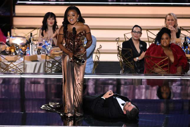Jimmy Kimmel lies onstage as US writer Quinta Brunson accepts the award for Outstanding Writing For A Comedy Series for “Abbott Elementary” during the 74th Emmy Awards at the Microsoft Theater in Los Angeles, California, on September 12, 2022. 