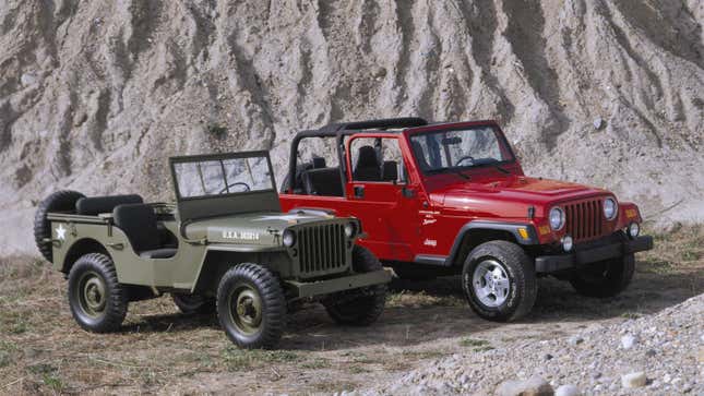 A photo of a green military Jeep and red Jeep Wrangler parked on dirt. 