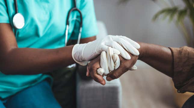 doctor wearing gloves and holding a patient's hands