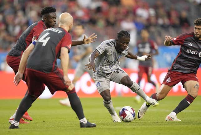Aug 20, 2023; Toronto, Ontario, CAN; CF Montr  al forward Kwadwo Opoku (90) controls the ball while defended by several Toronto FC players during the first half at BMO Field.