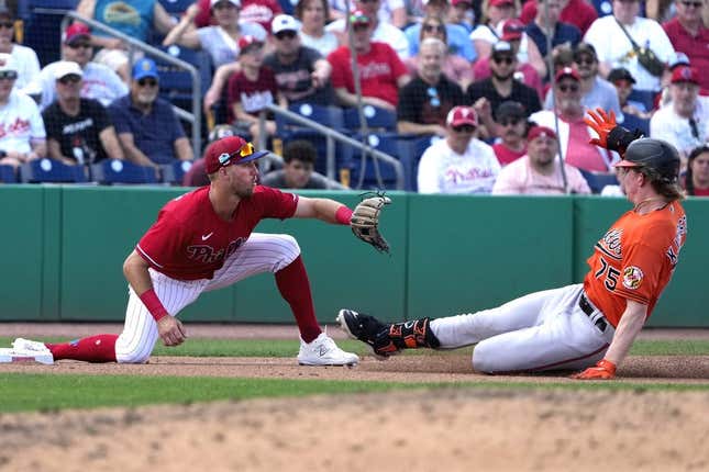 Mar 9, 2023; Clearwater, Florida, USA;  Baltimore Orioles outfielder Heston Kjerstad (75) slides safely into third as Philadelphia Phillies third baseman Alec Bohm (28) waits for the ball during the seventh at BayCare Ballpark.