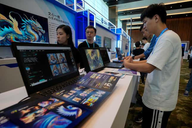 Visitors try out the AI chatbot Ernie Bot on the laptop computers at a booth promoting the AI chatbot during the Wave Summit in Beijing on Aug. 16, 2023. Chinese search engine and artificial intelligence firm Baidu on Thursday made its ChatGPT-equivalent language model available to the public, in a sign of a green light from Beijing which has in recent months taken steps to regulate the industry. (AP Photo/Andy Wong)