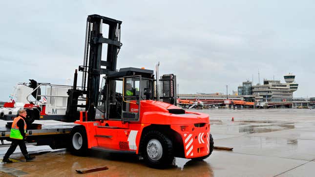 A forklift loads a so-called high-loader, used to load cargo onto planes, onto a transport vehicle at Tegel Airport in Berlin on October 14, 2020, before being moved to the capital's new BER Airport located in the southeast of the German capital.