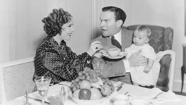 Father holding baby at dinner table