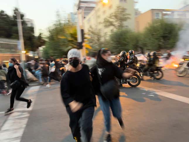 In this Monday, Sept. 19, 2022, photo taken by an individual not  employed by the Associated Press and obtained by the AP outside Iran,  women run away from anti-riot police during a protest of the death of a  young woman who had been detained for violating the country’s  conservative dress code, in downtown Tehran, Iran. 