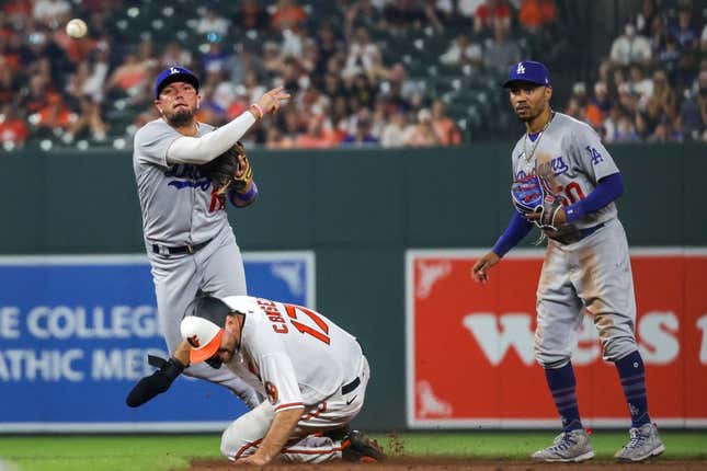 Jul 17, 2023; Baltimore, Maryland, USA;  Los Angeles Dodgers shortstop Miguel Rojas (11) throws to first base over a sliding Baltimore Orioles outfielder Colton Cowser (17) as second baseman Mookie Betts (50) looks on in the ninth inning at Oriole Park at Camden Yards.
