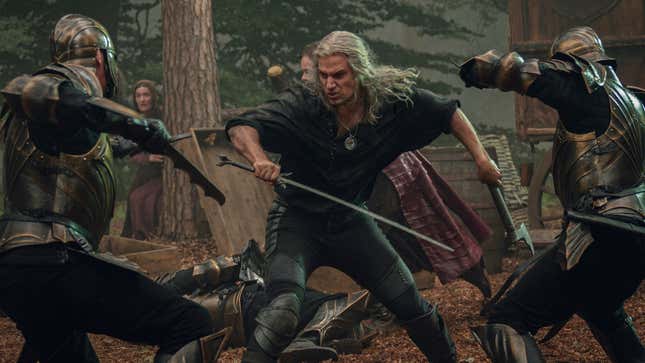 A Witcher still shows Geralt battling soldiers in a forest. 