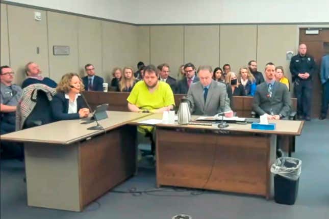 In this image taken from El Paso County District Court video, Anderson Lee Aldrich, 22, center, sits during a court appearance in Colorado Springs, Colo., Tuesday, Dec. Nov. 6, 2022. Aldrich, the suspect accused of entering a Colorado gay nightclub clad in body armor and opening fire with an AR-15-style rifle, killing five people and wounding 17 others, was charged by prosecutors Tuesday with 305 criminal counts including hate crimes and murder. 