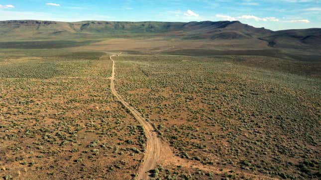 A dirt road stretches off into the distance of the desert between Oregon and Nevada