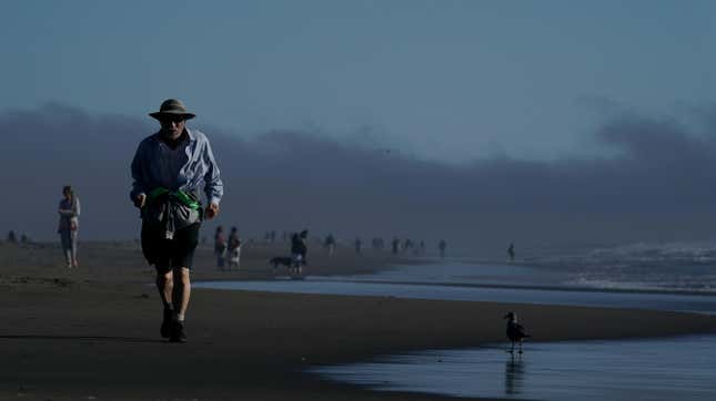 A man runs on the shore at Ocean Beach, Monday, August. 14, 2023, in San Francisco. 