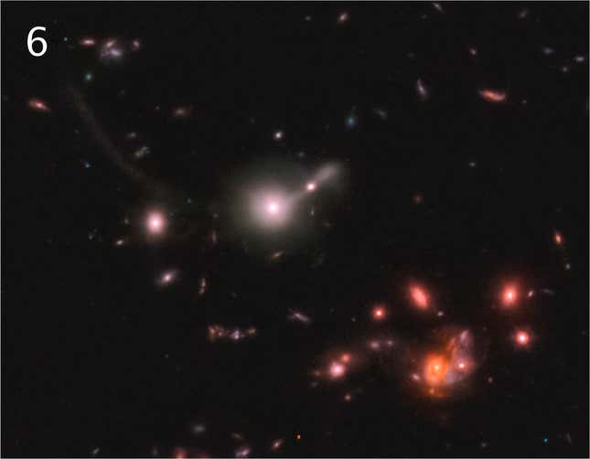 Una galaxia rosada con cola en el centro y un grupo de galaxias rojizas en la parte inferior derecha