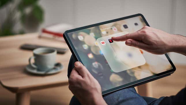 A photo of a person using an iPad tablet. 