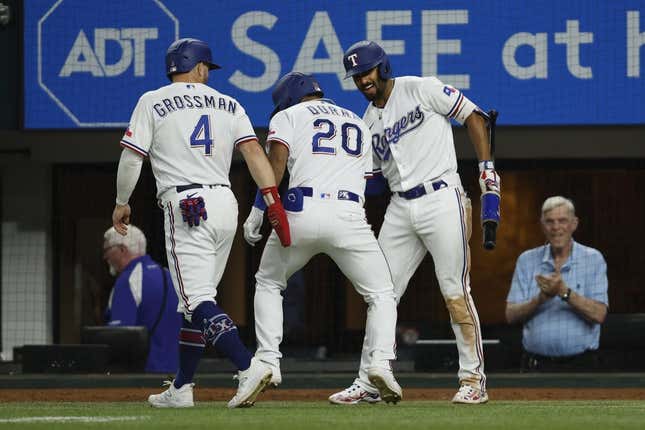 Jul 17, 2023; Arlington, Texas, USA; Texas Rangers left fielder Ezequiel Duran (20) is congratulated by designated hitter Robbie Grossman (4) and second baseman Marcus Semien (2) after hitting a two-run home run in the sixth inning against the Tampa Bay Rays at Globe Life Field.
