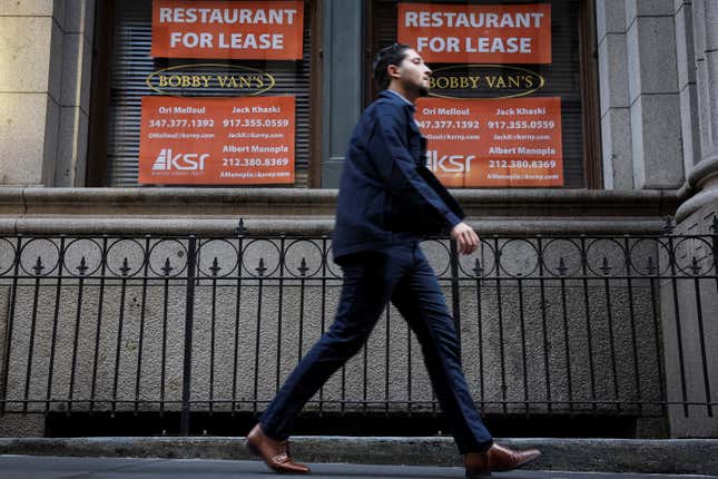 A man walks past "for lease" signs on the former location of Bobby Van's Steakhouse in the financial district of New York City.