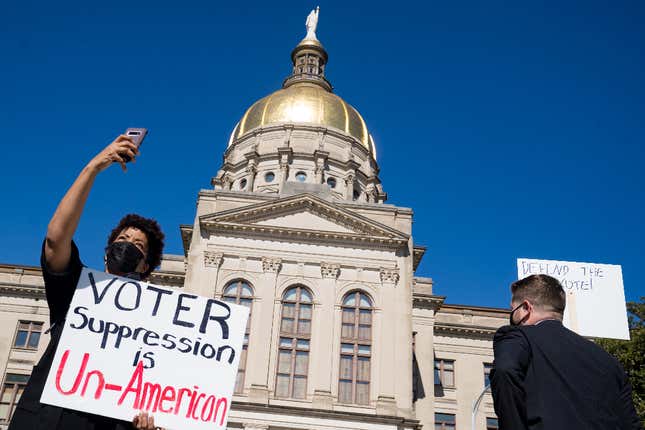 Demonstrators stand outside of the Capitol building in opposition to House Bill 531 on March 8, 2021 in Atlanta, Georgia. HB531 will restrict early voting hours, remove drop boxes, and require the use of a government ID when voting by mail.