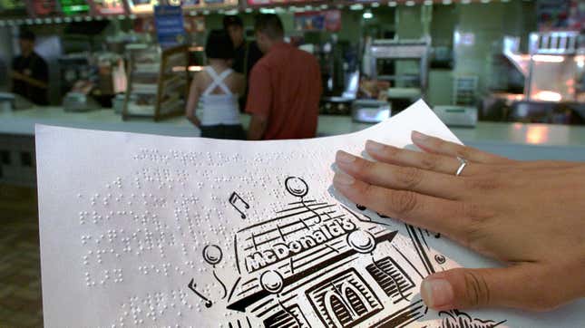 A patron at a Toronto McDonald’s holds the restaurant’s braille menu.