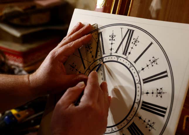 A man working on a clock face. 