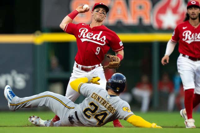 Cincinnati Reds shortstop Matt McLain (9) turns a double play as Milwaukee Brewers catcher William Contreras (24) slides into second in the first inning of the MLB baseball game between the Cincinnati Reds and the Milwaukee Brewers at Great American Ball Park in Cincinnati on Saturday, July 15, 2023.