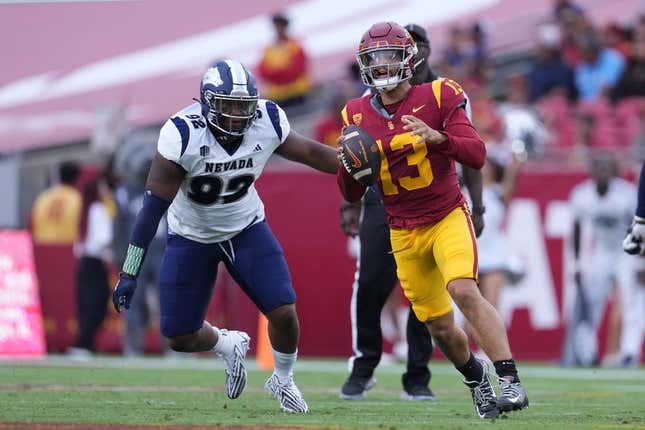 Sep 2, 2023; Los Angeles, California, USA; Southern California Trojans quarterback Caleb Williams (13) is pressured by Nevada Wolf Pack defensive end Dion Washington (92) in the second half at United Airlines Field at Los Angeles Memorial Coliseum.
