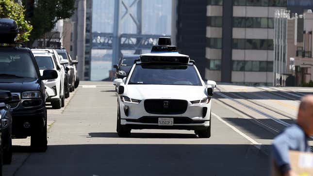 Front view of a Waymo driverless taxi as it drives down a road in San Francisco.