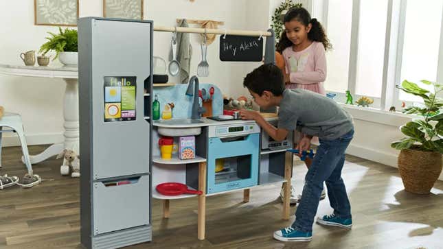 Two children playing with an Alexa enabled Amazon toy kitchen