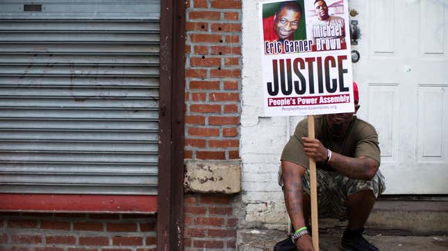 A protester holds up a sign with images of both Eric Garner and Michael Brown, both killed at the hands of police officers, during an August 2014 action on Staten Island in New York City.
