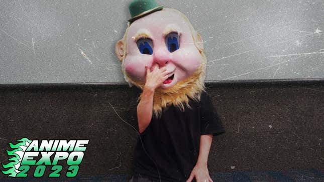 Nier creator Yoko Taro covers his mouth while wearing a creepy leprechaun mask.