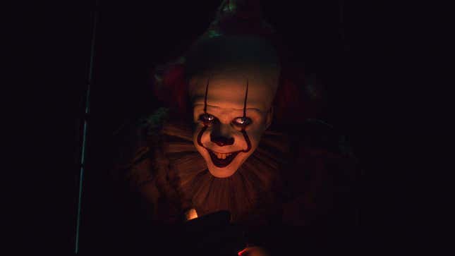 Pennywise, the clown from It, grins under red lighting.