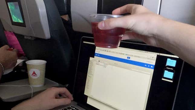 Image for article titled Breaking: Flight Attendant Currently Attempting To Pass Cup Of Cranberry Juice Over Your Laptop