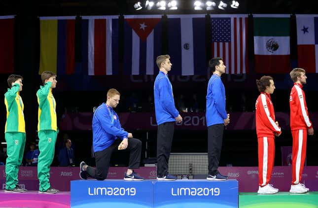 Gold medalist Race Imboden of United States takes a knee during the National Anthem Ceremony in the podium of Fencing Men’s Foil Team Gold Medal Match Match on Day 14 of Lima 2019 Pan American Games at Fencing Pavilion of Lima Convention Center on August 09, 2019 in Lima, Peru.