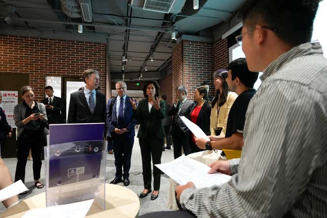 U.S. Commerce Secretary Gina Raimondo, center, meets with students during a visit to the New York University Campus in Shanghai, China, Wednesday, Aug. 30, 2023. (AP Photo/Andy Wong, Pool)