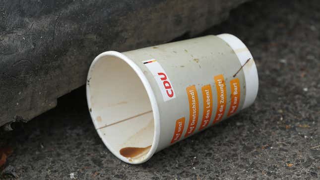 A photo of an empty coffee cup by the side of the road. 