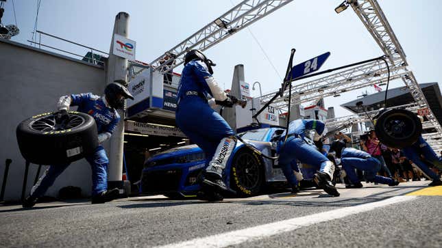 The pit crew for the NASCAR Next Gen Chevrolet ZL1 sprinting around their car during a stop