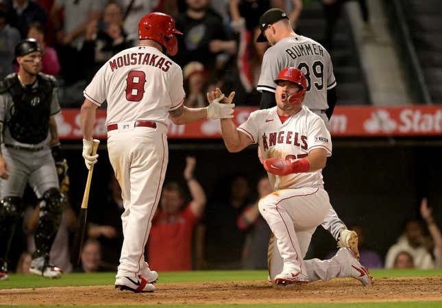 Jun 26, 2023; Anaheim, California, USA; Los Angeles Angels center fielder Mike Trout (27) celebrates with first baseman Mike Moustakas (8) after scoring from third on a wild pitch by Chicago White Sox relief pitcher Aaron Bummer (39) to win the game in the ninth inning at Angel Stadium.