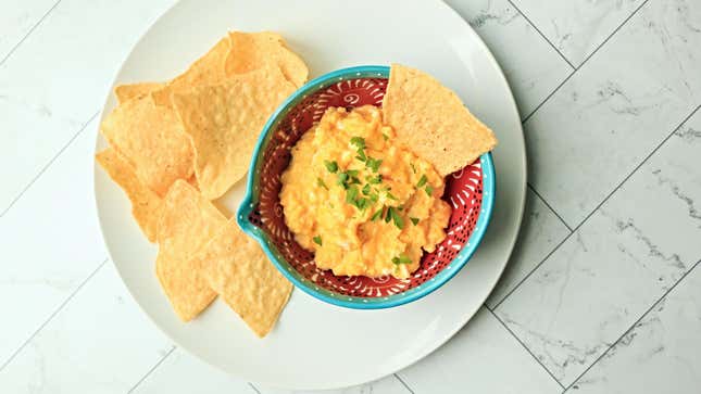 Tortilla chips on a plate next to a bowl of soft scrambled eggs.