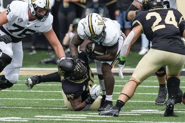 Sep 9, 2023; Winston-Salem, North Carolina, USA; Vanderbilt Commodores running back Patrick Smith (4) is tackled by Wake Forest Demon Deacons defensive lineman Jasheen Davis (30) during the first quarter at Allegacy Federal Credit Union Stadium.