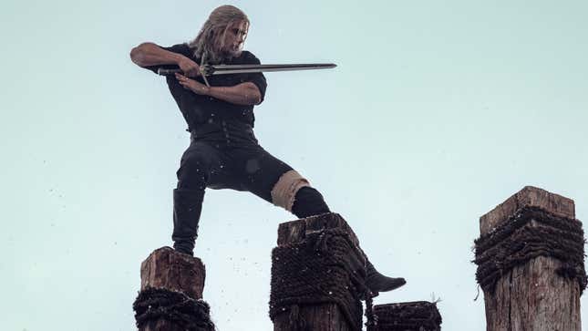 A Witcher still shows Henry Cavill sword training while standing on wooden beams. 
