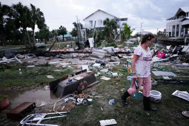 Jewell Baggett walks amidst debris strewn across the yard where her mother’s home had stood in Horseshoe Beach, Florida, after the passage of Hurricane Idalia on August 30, 2023.