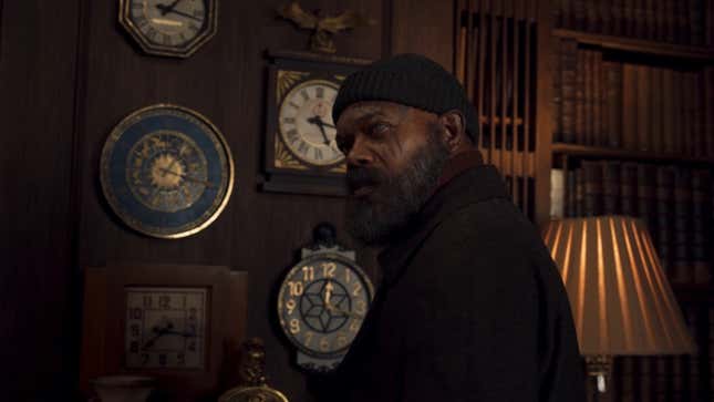 Nick Fury looks over his shoulder with a wall of clocks before him.