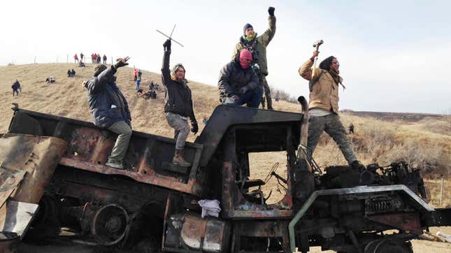 Protesters against the Dakota Access oil pipeline stand on a burned-out truck near Cannon Ball, North Dakota in November 2016. 