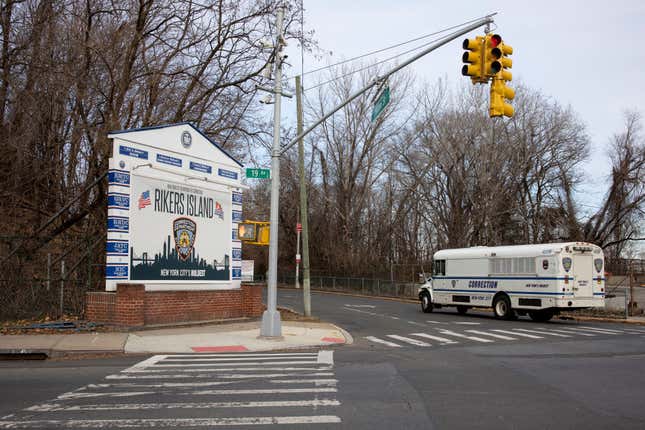 A Department of Corrections bus, used to transport prisoners, drives up to the entrance of the bridge that connects to Rikers Island, January 15, 2022, in Queens, New York.