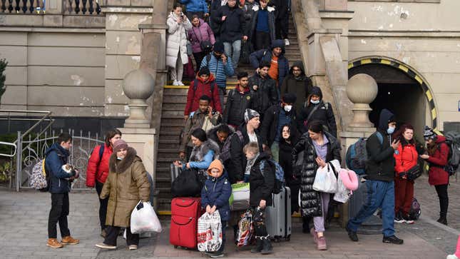Evacuees from the city of Kyiv are seen walking down stairs at a railway station.