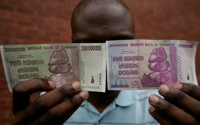 A man holds up newly issued 200 million and 500 million Zimbabwe dollar notes in the capital Harare December 12, 2008. Zimbabwe's central bank on December 4, 2008 injected 80 trillion Zimbabwe dollars ($8 million) in new bank notes into the economy in a bid to end cash shortages that have seen hordes besieging banks amid a deepening economic crisis. REUTERS/Philimon Bulawayo (ZIMBABWE) - RTR22IKG