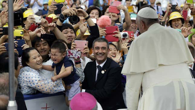 A child cries as his mother holds him up to Pope Francis in Seoul, Korea.