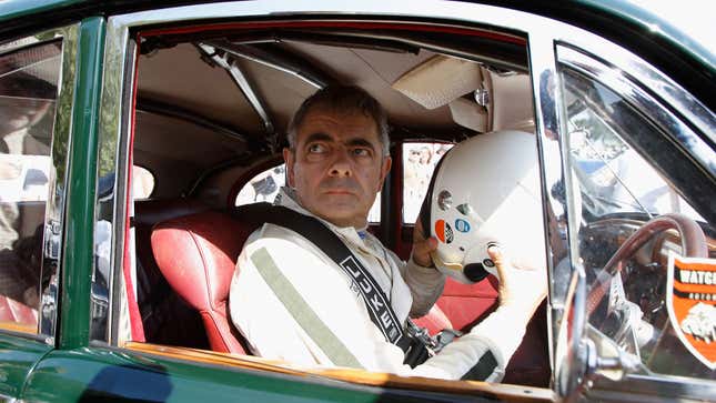 A photo of Rowan Atkinson in a vintage race car. 